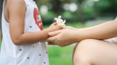 female-hands-holding-hands-little-girl-with-flowers-family